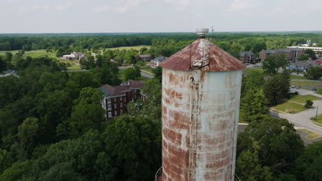 Aerial-drone-approaches-old-rusty-water-tower-in-Fort-Harrison-state-park