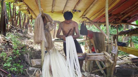 Native-Filipino-man-stripping-Abaca-fibers-on-serrated-knife-at-harvesting-site-in-Virac,-Catanduanes,-Philippines