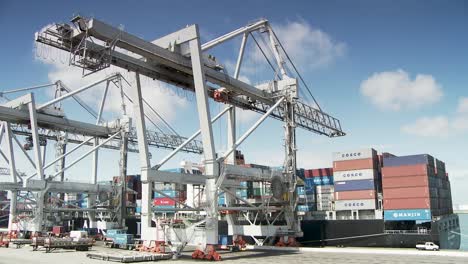 Weiße-Containerkräne-Laden-Schiff-Im-Frachthafen,-Sonniger-Sommertag