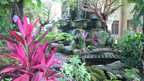 Dolly-Shot-of-a-Botanical-Garden-with-Waterfall-at-a-Temple-in-Chonburi,-Thailand