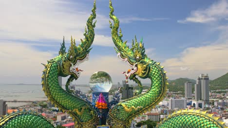 Grüner-Drache-Und-Seine-Kristallkugel-überblicken-Anmutig-Das-Stadtbild-Von-Chonburi,-Thailand