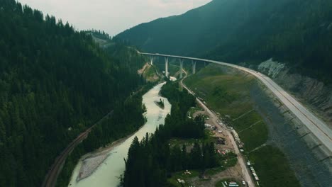 Cinematic-aerial-footage-of-the-kicking-horse-river-valley-with-the-park-bridge-in-view,-partly-hazy-due-to-the-wildfires-in-Canada-at-time-of-Recording,-Drone,-British-Columbia