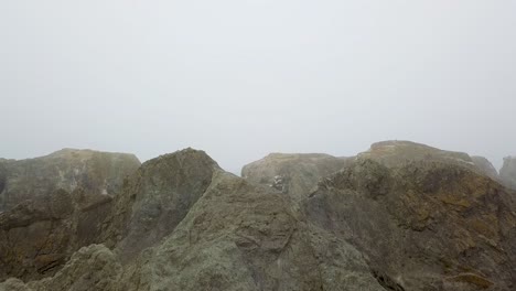 Coquille-Point,-Bandon-Oregon-Coast,-Fly-Over-Rocks-to-Reveal-Water-and-Fog