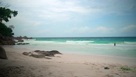 Strand,-Gefilmt-Auf-Den-Seychellen-Bei-Tag,-Gefilmt-Mit-Sanfter-Bewegung-Und-Wellen,-Die-Langsam-Auf-Den-Bach-Und-Die-Granitfelsen-Zulaufen
