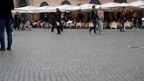 Menschen,-Die-über-Die-Piazza-Navona-In-Rom-Laufen,-Mit-Straßencafé-Im-Hintergrund