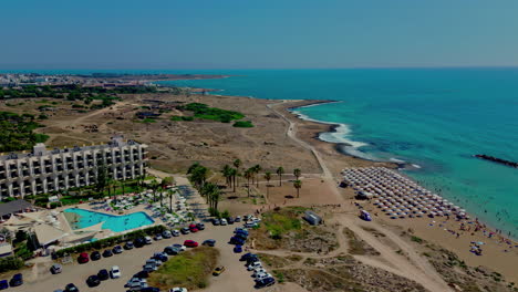Toma-Aérea-De-Camiones-De-Un-Resort-De-Playa-Junto-A-Un-Mar-Turquesa-En-El-Mediterráneo