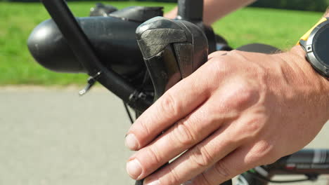 "Close-up-of-a-hand-resting-on-a-bicycle-handlebar