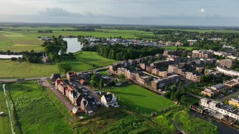 Aerial-panning-shot-of-new-housing-projects-on-a-beautiful-summer-evening-as-teh-sun-sets,-in-the-town-of-Weesp-just-outside-of-Amsterdam-Netherlands