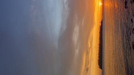 Vertikaler-Zeitraffer-Einer-Insel-Mit-Säulenkiefern-Und-Farbenprächtigem-Sonnenuntergang-Auf-Der-Insel-Pines,-Neukaledonien