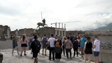 Gruppe-Von-Touristen,-Die-Neben-Centauro-Di-Igor-Mitoraj-In-Pompeji-Dem-Reiseführer-Zuhören