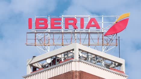 Spanish-airline,-Iberia,-logo-and-sign-located-on-top-of-a-building-in-Madrid,-Spain