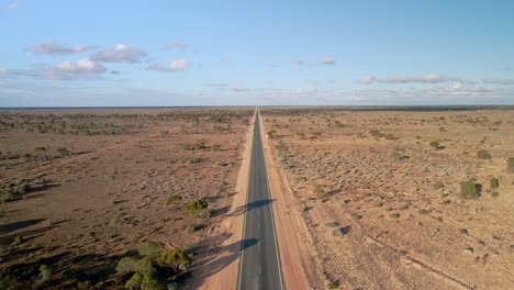 Aerial-view-above-90-miles-straight-road,-australia-on-a-sunny,-desert-outback,-landing,-drone-shot