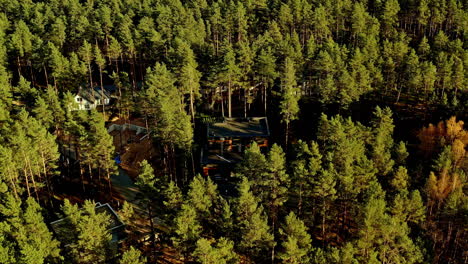 aerial-of-white-and-green-resort-buildings-in-a-forest