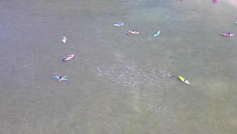 Aerial-top-down-shot-showing-group-of-kayaker-in-canoe-on-ocean-during-sunny-day