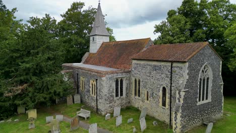 A-pan-of-All-Saints-church-in-West-Stourmouth,-with-the-graveyard-in-view