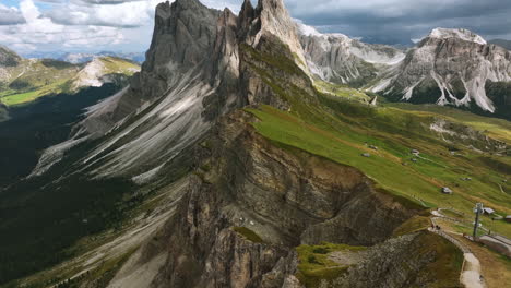 Drone-shot-tilting-backwards-away-from-the-Seceda-ridge,-summer-in-Dolomites,-Italy