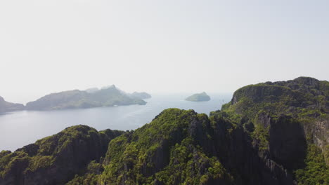 Cinematic-aerial-footage-of-the-cliffs-with-trees-and-the-ocean-in-the-background-flying-down-revealing-more-and-more-view-in-Palawan,-Philippines,-Asia,-Drone