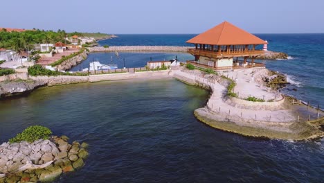 Vista-Aérea-Que-Muestra-El-Puerto-Deportivo-De-La-Romana-Y-El-Restaurante-Captain-Kidd-Durante-El-Cielo-Azul-Y-La-Luz-Del-Sol-En-República-Dominicana.