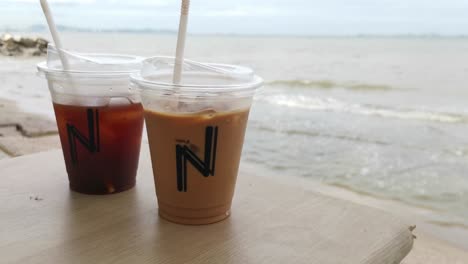 Zwei-Eiskaffees-Auf-Einem-Tisch-Mit-Verschwommenem-Thailändischem-Strandhintergrund