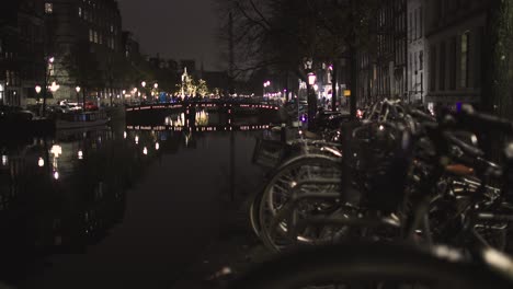 Amsterdamer-Kanal-Mit-Fahrrädern-Im-Vordergrund-Bei-Nacht-In-Den-Niederlanden-In-Den-Kalten-Winterkanälen