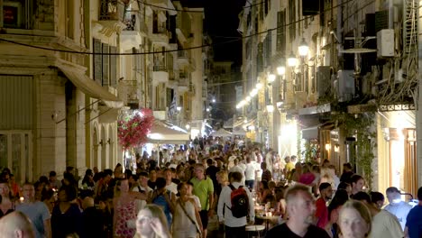 Überfüllte-Straße,-Menschen,-Die-In-Einer-Sommernacht-Auf-Der-Hauptstraße-In-Korfu,-Kerkyra,-Griechenland,-Spazieren,-Echtzeitaufnahmen