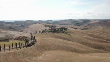 Stunning-Tuscany-road-with-farmhouse---drone-surrounding-the-farmhouse-and-road