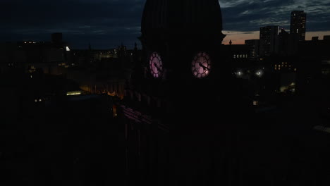 Closeup-Drone-Shot-of-Leeds-Town-Hall-Clock-Tower-and-Leeds-City-Centre-Skyline-at-Dawn-in-Low-Light