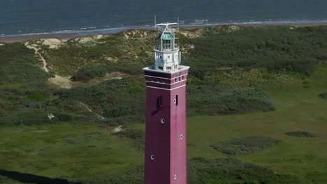 Flying-backwards-at-Westhoofd-Lighthouse-with-sea-in-background,-aerial
