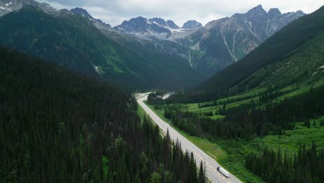 Flying-above-mountain-highway-surrounded-by-forest
