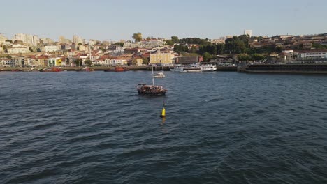 Aerial-tracking-shot-of-Tourist-Boat-Sailing-Douro-River-in-Porto,-Portugal