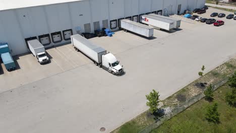 Drone-shot-of-truck-backing-into-logistics-and-shipping-hub