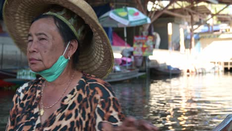 Three-women-vendors-paddling-their-boats-towards-the-left-side-of-the-frame-in-Damnoen-Saduak-Floating-Market