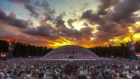 Lapso-De-Tiempo-De-Nubes-Rodantes-Y-Un-Cielo-Ardiente-épico-Sobre-El-Escenario-En-El-Festival-De-Canto-Y-Danza-De-Letón,-Ciudad-De-Riga