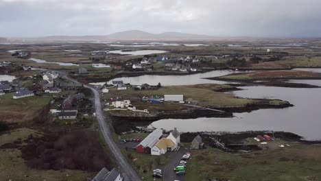 Descending,-wide-angle-drone-shot-of-the-town-of-Lochmaddy,-focusing-on-the-Taigh-Chearsabhagh-Museum-and-Arts-Centre