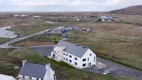 Drone-shot-of-the-Cnoc-Soilleir-building-in-the-village-of-Daliburgh-in-South-Uist,-looking-North