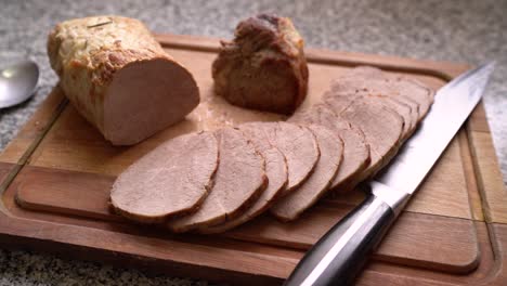 Meat-Slices-Cooked-in-the-Oven-with-Knife-on-Wooden-Chopping-Board