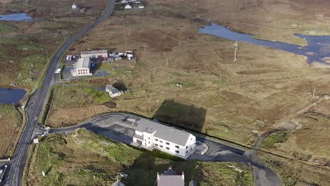 Dynamic-tilting-shot-of-the-Cnoc-Soilleir-building-in-the-village-of-Daliburgh-in-South-Uist,-looking-North-toward-Lochmaddy