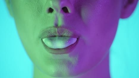 Close-up-happy-young-woman-chews-gum-bubble,-dramatic-blue-green-lightning
