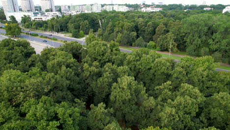 Aerial-flyover-forest-and-highway-of-Warsaw-with-residential-area-in-background-in-suburb-area