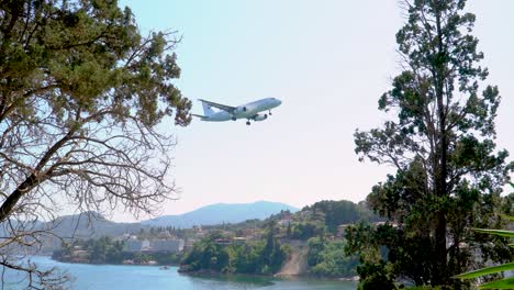 Airplane-Passes-close-to-Land-in-Corfu-Kerkyra-Greece,-View-from-Pontikonisi-Real-TIme-Footage