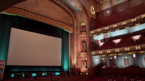 Theater-stage-with-screen-and-empty-chairs-in-Tuschinski-cinema,-Amsterdam