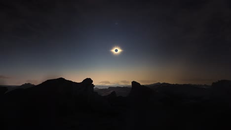 Timelapse-movement-of-clouds-above-solar-eclipse-on-rocky-landscape-at-dusk