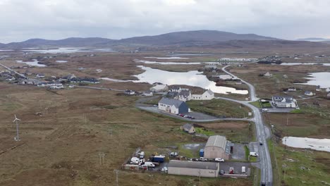 Drone-shot-of-the-Cnoc-Soilleir-building-with-the-village-of-Daliburgh-in-South-Uist-in-the-background