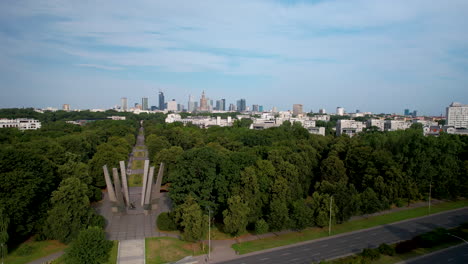 Aerial-wide-shot-of-forest-avenue-and-skyline-of-Warsaw-during-sunny-day-in-background,-Poland---Panorama-view