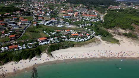 Aerial-Landscape-Pan-Shot-of-Vacational-Area-and-Cozy-Beach-with-Emerald-Water