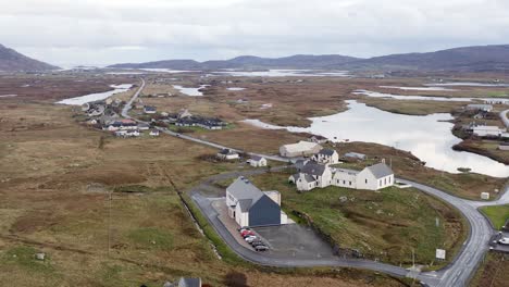 Counter-clockwise-dollying-shot-of-the-Cnoc-Soilleir-building-in-the-village-of-Daliburgh-in-South-Uist,-looking-toward-Lochboisdale