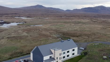 Drone-shot-of-the-Cnoc-Soilleir-building-in-the-village-of-Daliburgh-in-South-Uist,-part-of-the-Outer-Hebrides-of-Scotland