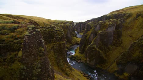Tiro-Tranquilo-De-Un-Gran-Cañón-En-Islandia-Con-Río-Azul-En-El-Medio