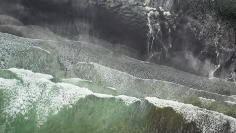 Top-down-aerial-with-spinning-motion-shot-of-big-waves-breaking-on-Talisker-bay,-Isle-of-Skye