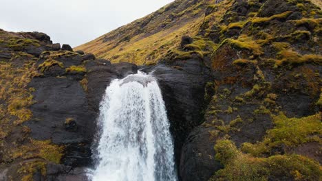 Drone-cinematically-shows-a-waterfall-in-moss-covered-Iceland